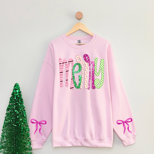Light pink Merry Christmas crewneck sweatshirt with colorful pink and green patterned lettering, faux glitter details, and pink bow graphics on both sleeves\. Preppy coquette Christmas sweatshirt for women\.
