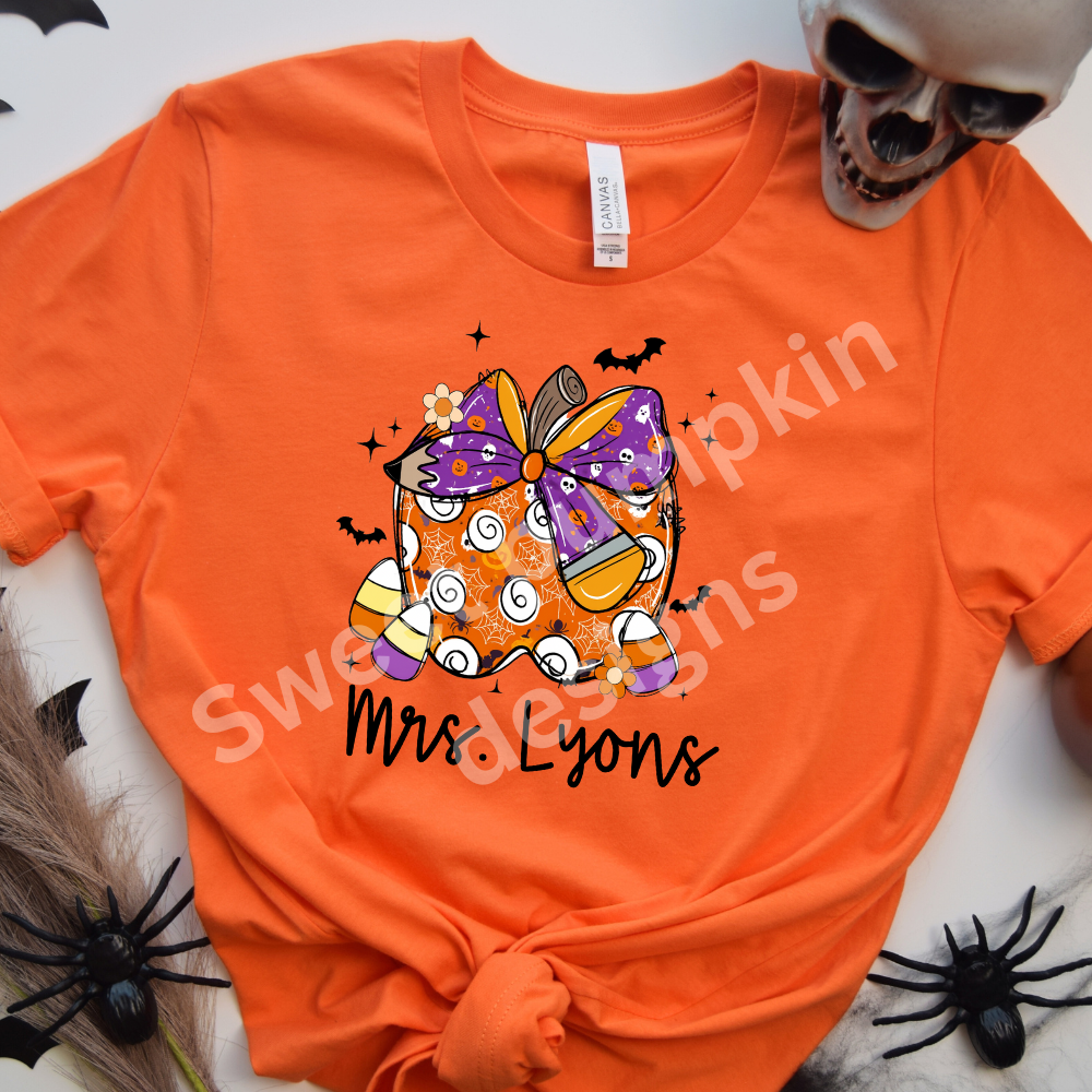 Cute custom Halloween teacher tee with name and festive apple design printed on Bella + Canvas unisex shirt, ideal for fall school outfits.