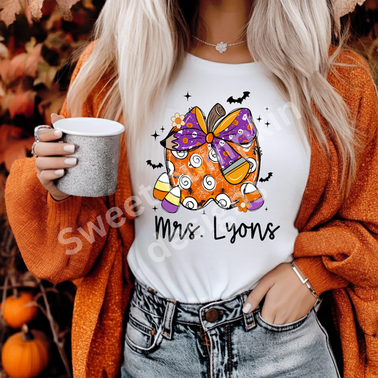 Custom Halloween teacher shirt with personalized name and Halloween apple design featuring candy corn on a soft Bella + Canvas tee.