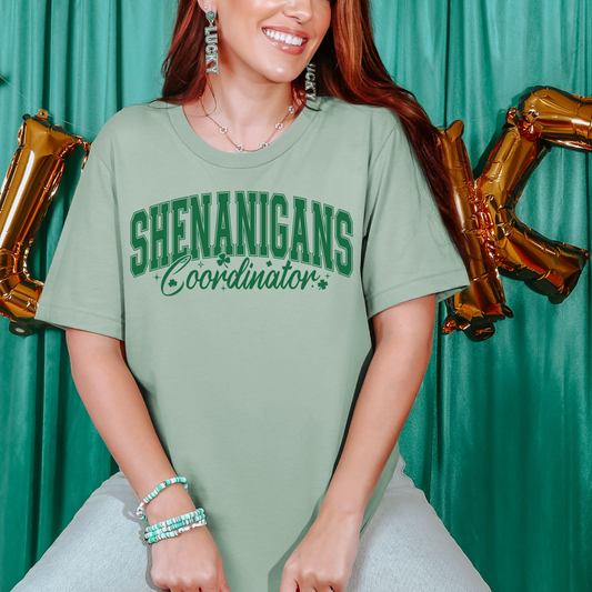 Comfort Colors St Patrick’s Day shirt that says Shenanigans Coordinator, festive green lucky holiday outfit for women flat lay mockup