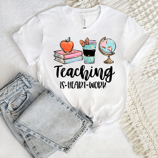 Teacher wearing Teaching Is a Work of Heart shirt in classroom, cute teacher appreciation gift tee perfect for back to school and end of year teacher gift