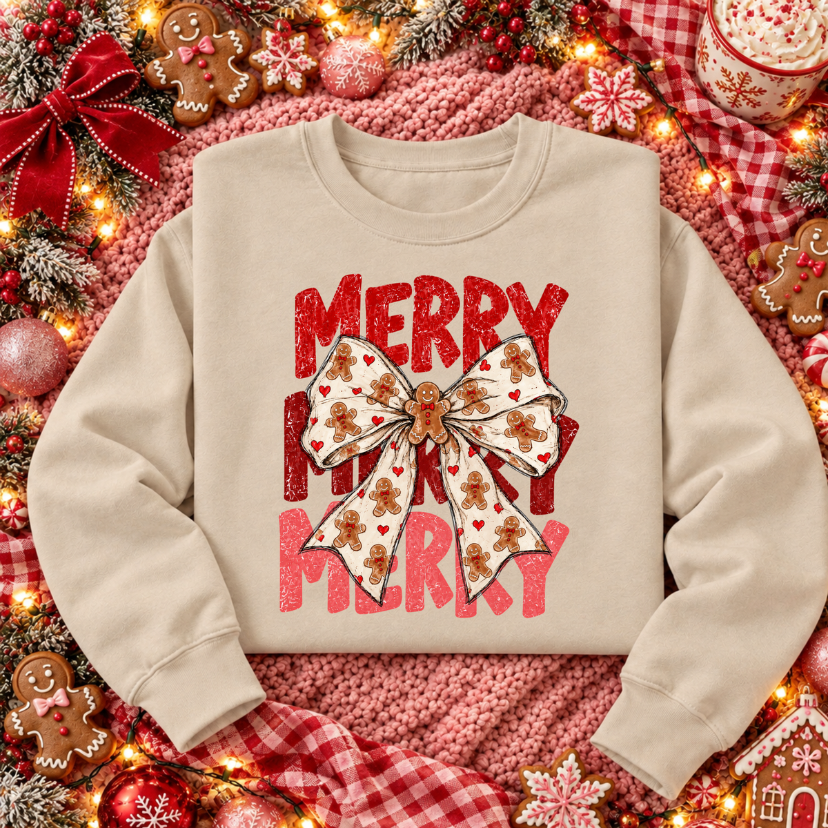 Sand gingerbread bow Christmas sweatshirt with distressed red and pink Merry Merry Merry lettering and gingerbread cookie ribbon, styled on a festive pink and red Christmas flat lay.