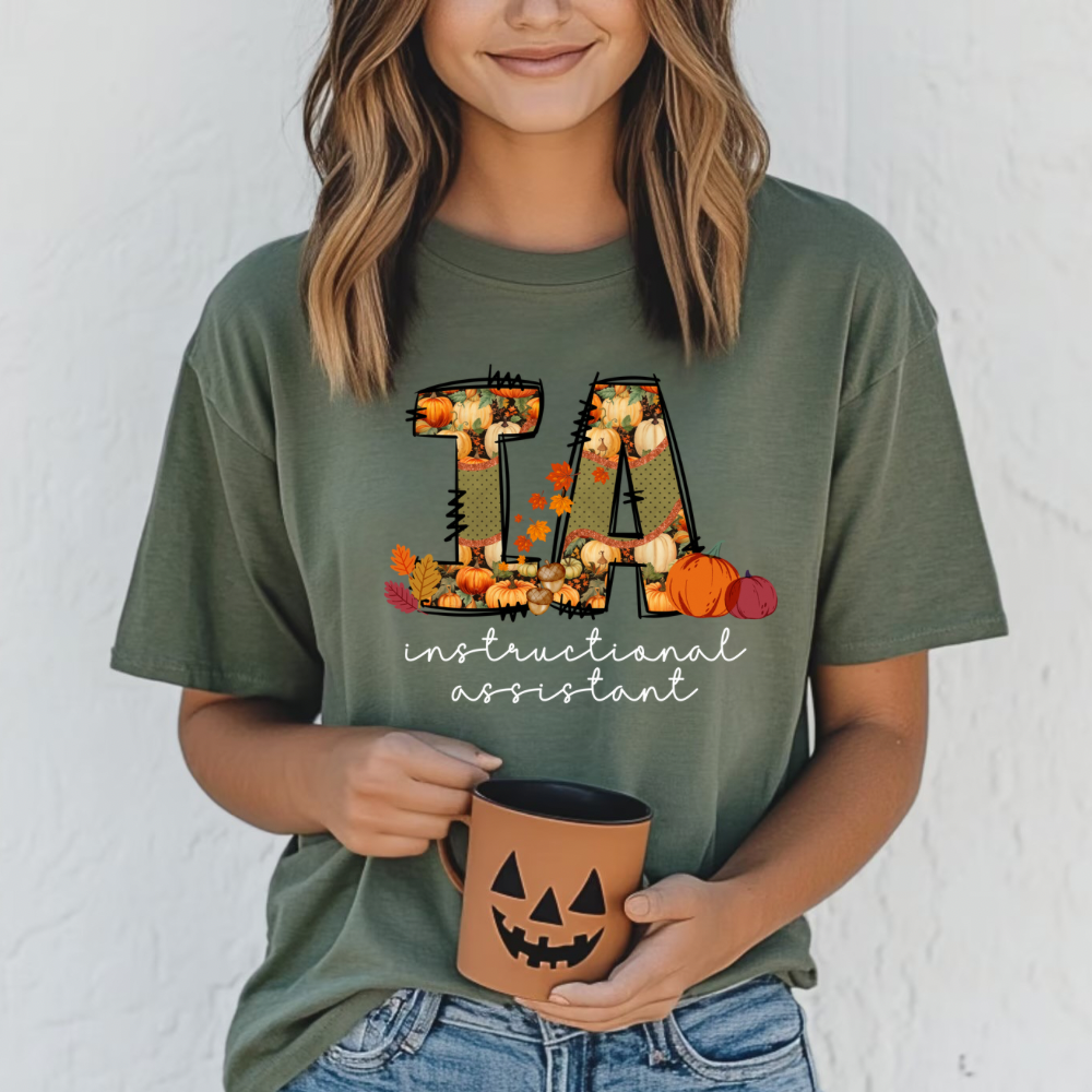 Woman wearing Comfort Colors instructional assistant fall t-shirt with pumpkins and autumn leaves, casual teacher assistant outfit for fall