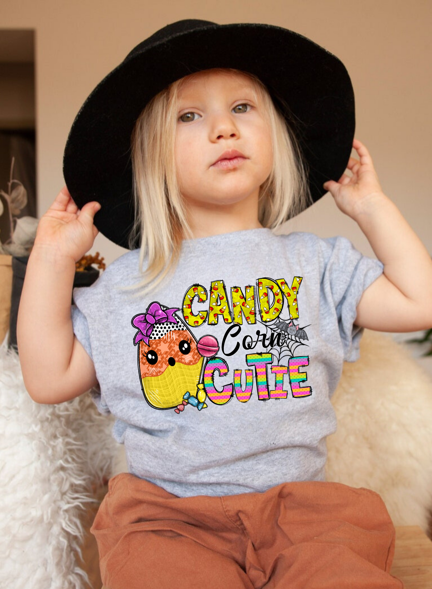 An adorable Halloween shirt for girls with the phrase 'Candy Corn Cutie', featuring a preppy and playful design. The shirt adds a unique touch to her Halloween outfit, embodying the essence of cute Halloween fun.