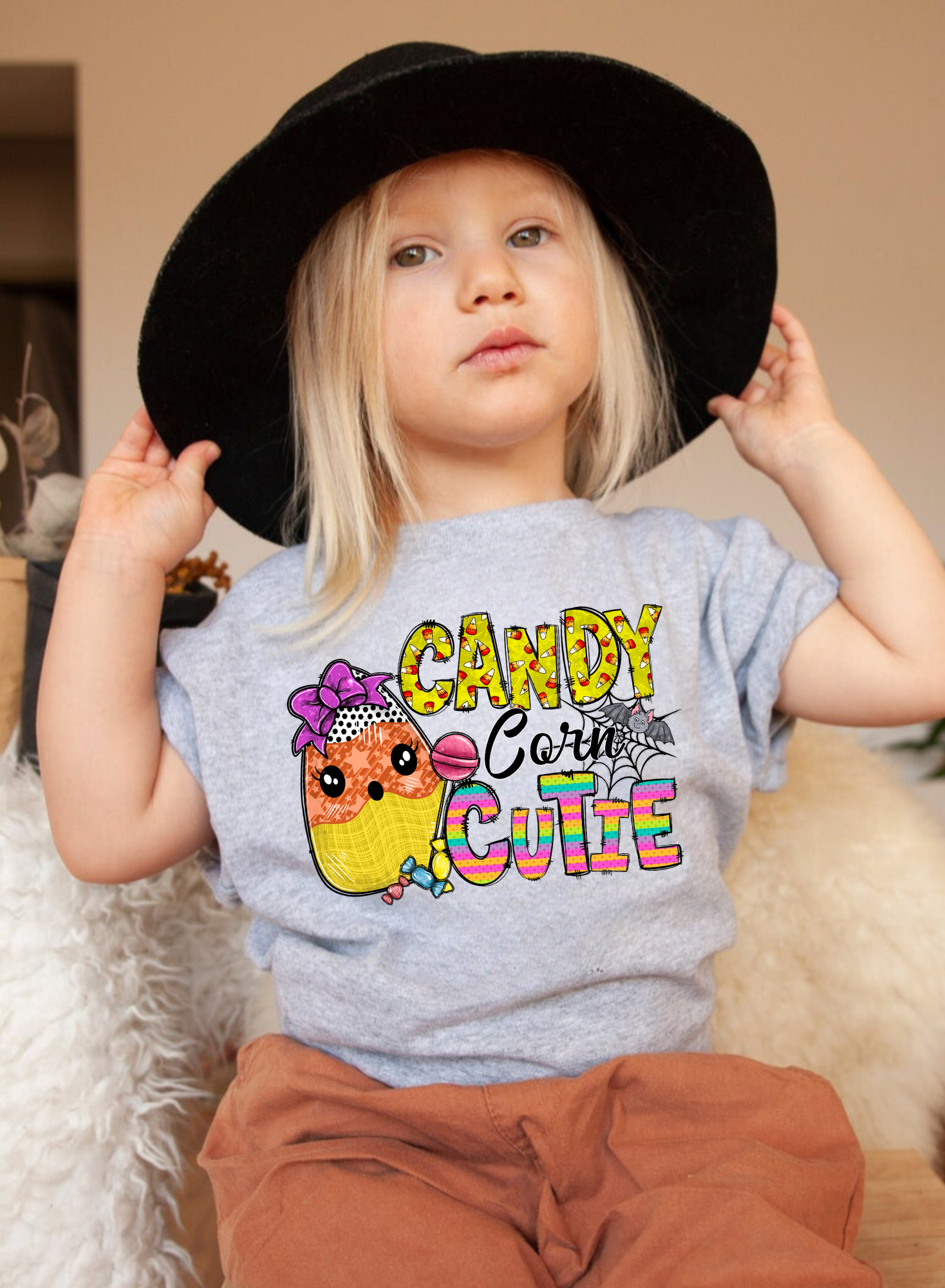 An adorable Halloween shirt for girls with the phrase 'Candy Corn Cutie', featuring a preppy and playful design. The shirt adds a unique touch to her Halloween outfit, embodying the essence of cute Halloween fun.