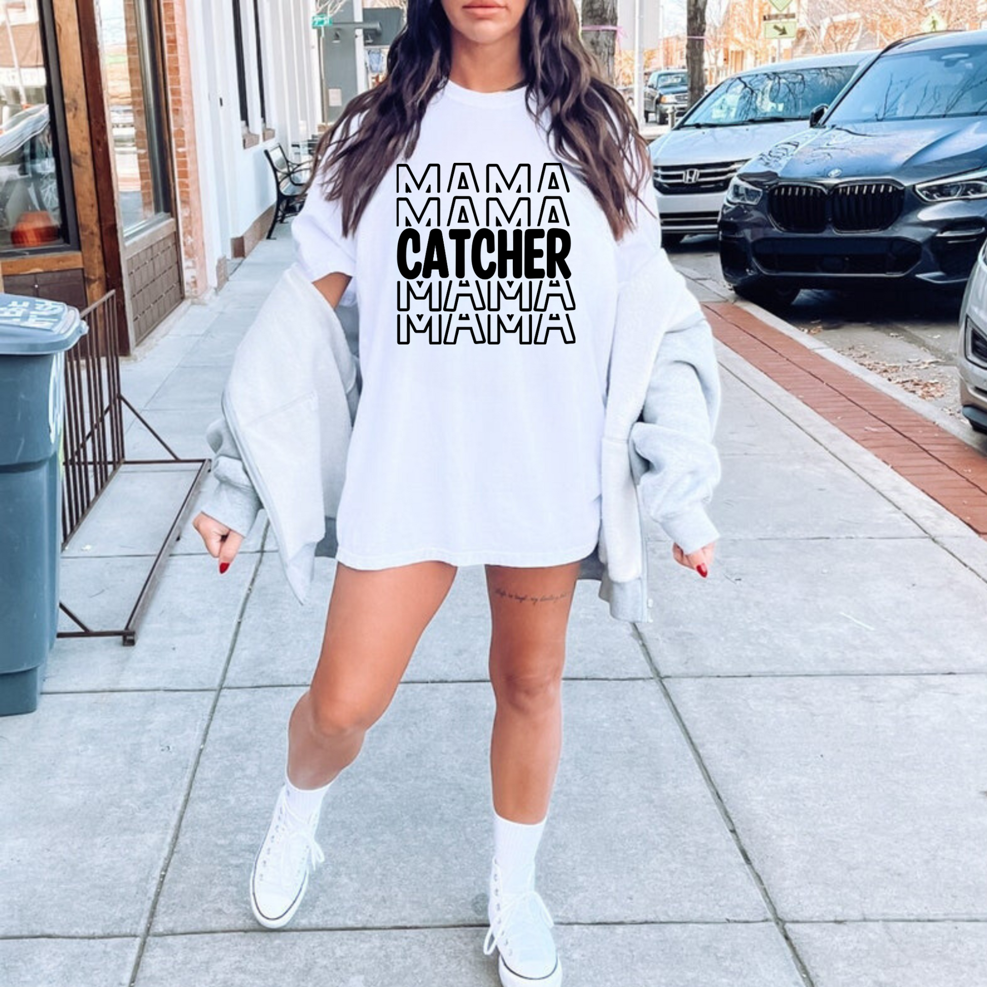 A stylish baseball mom shirt with the text 'Catcher Mama', perfect for game day and showing off your love for baseball. The shirt features a comfortable fit and is a great choice for a mom outfit at the baseball game.