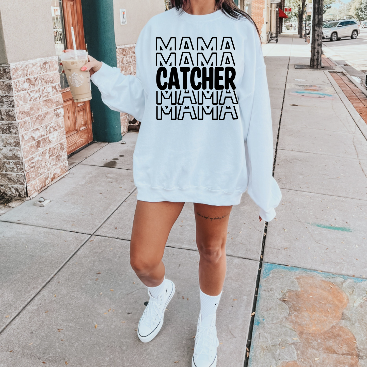 A comfortable and stylish baseball mom crewneck sweatshirt featuring the words 'Catcher Mama'. This baseball-themed sweatshirt is an ideal mom outfit for game days at the baseball game, celebrating the dedicated role of a catcher mom.