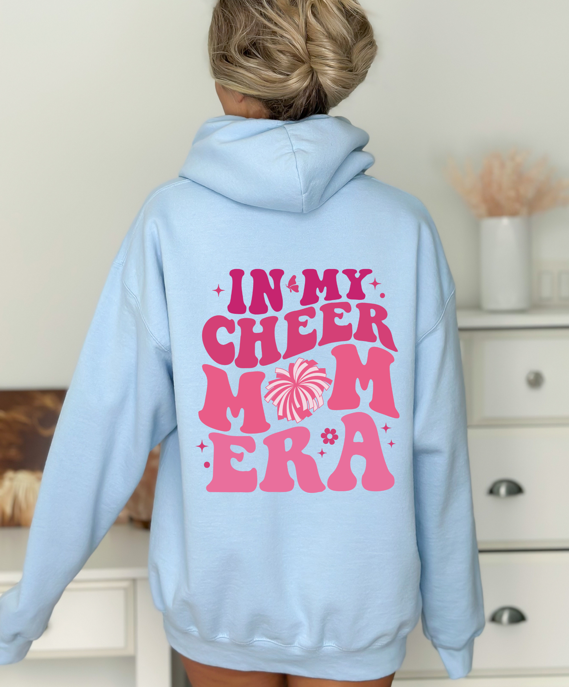 A comfortable hoodie for cheer moms with the text 'In My Cheer Mom Era'. This sweatshirt is ideal for showcasing support for cheerleaders, offering a mix of comfort and style in a humorous design.