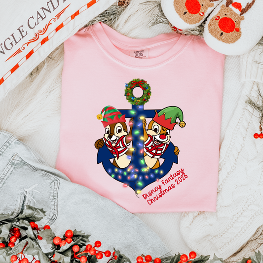 Pink Comfort Colors Christmas cruise T-shirt featuring festive holiday chipmunks and a decorated anchor, styled with Christmas mouse ears and holiday decorations on a cruise ship deck.
