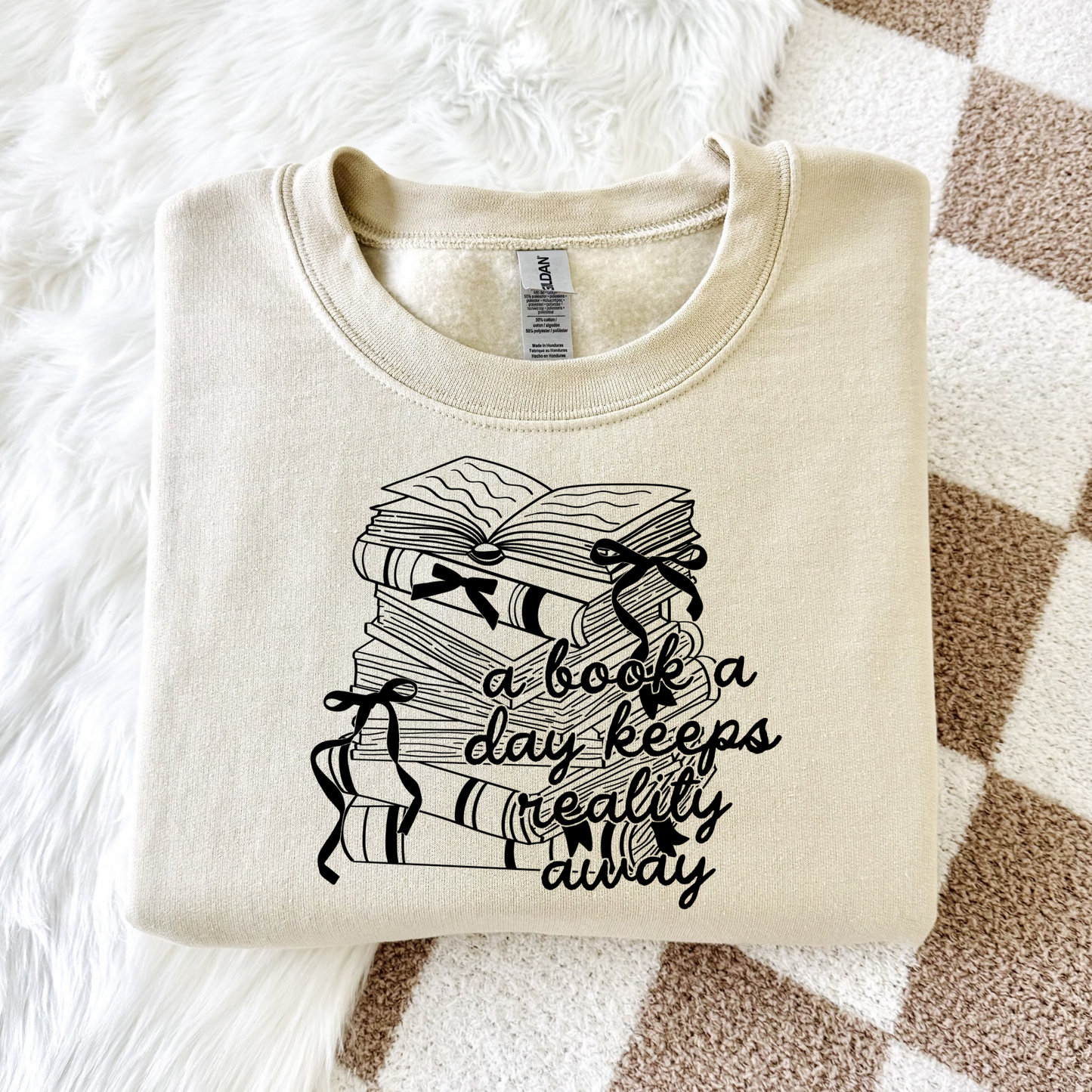 Cozy crewneck sweatshirt for women with the phrase “a book a day keeps reality away,” styled with soft neutral tones for a cozy girl reading aesthetic, perfect for book lovers and comfy everyday wear