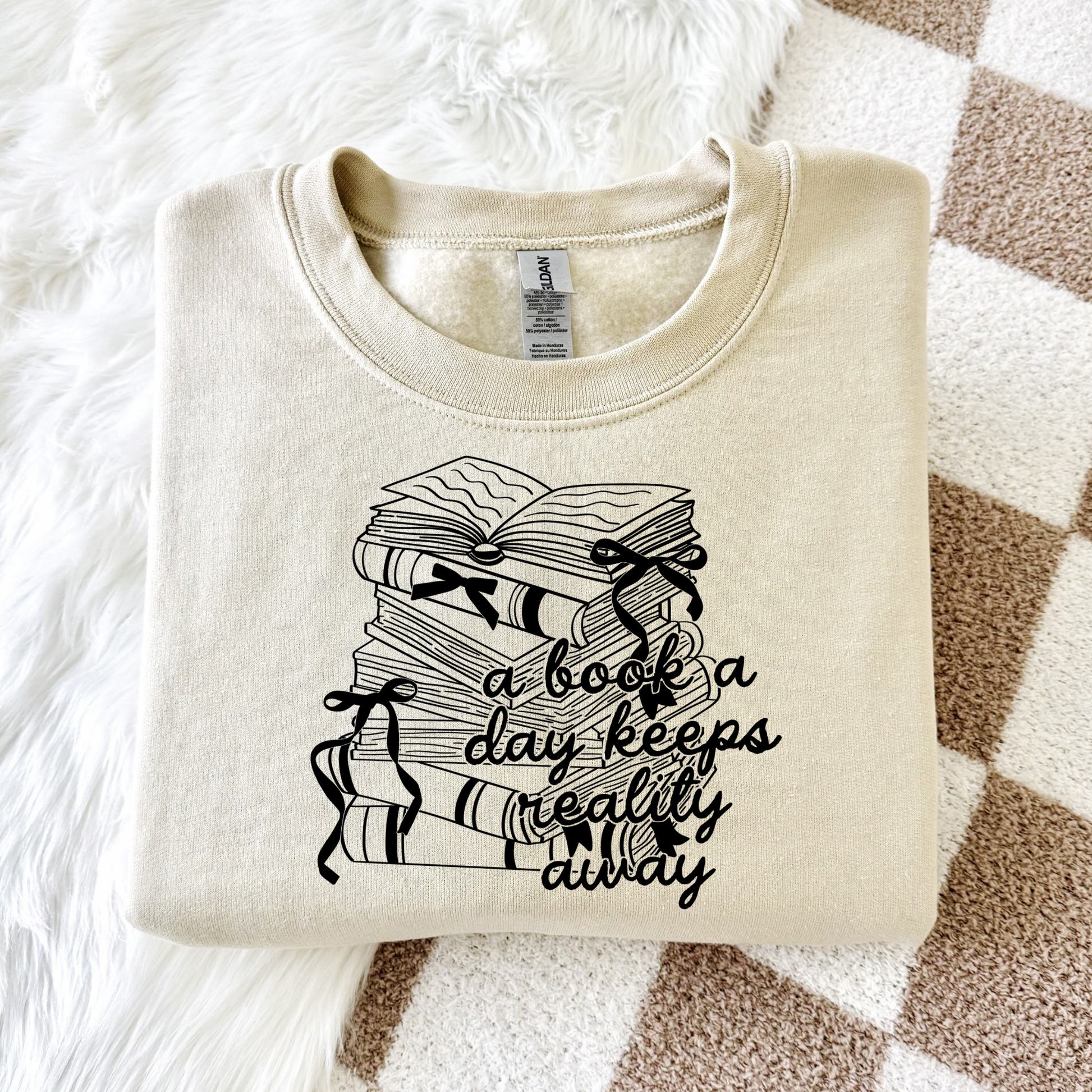 Cozy crewneck sweatshirt for women with the phrase “a book a day keeps reality away,” styled with soft neutral tones for a cozy girl reading aesthetic, perfect for book lovers and comfy everyday wear