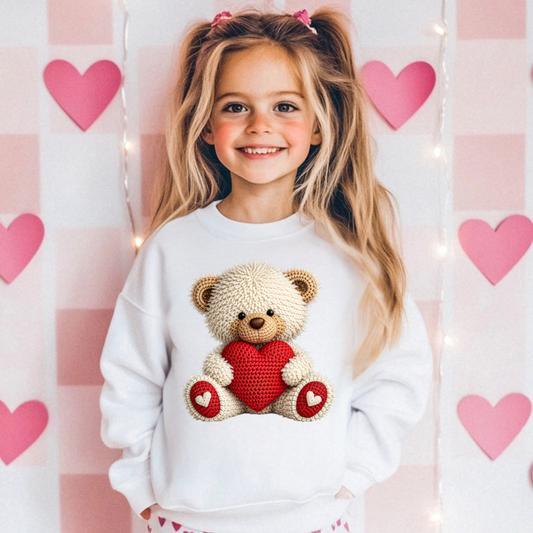 Girl wearing a faux crochet teddy bear Valentine’s Day sweatshirt styled for a cozy winter outfit