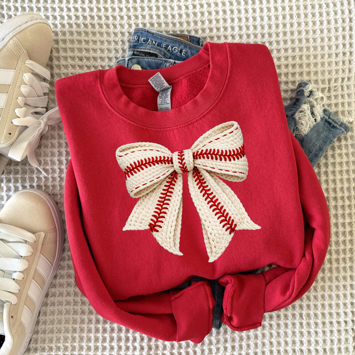 Cozy women’s crewneck sweatshirt featuring a faux yarn style baseball bow graphic, perfect for baseball moms, game day outfits, and casual sporty everyday wear.