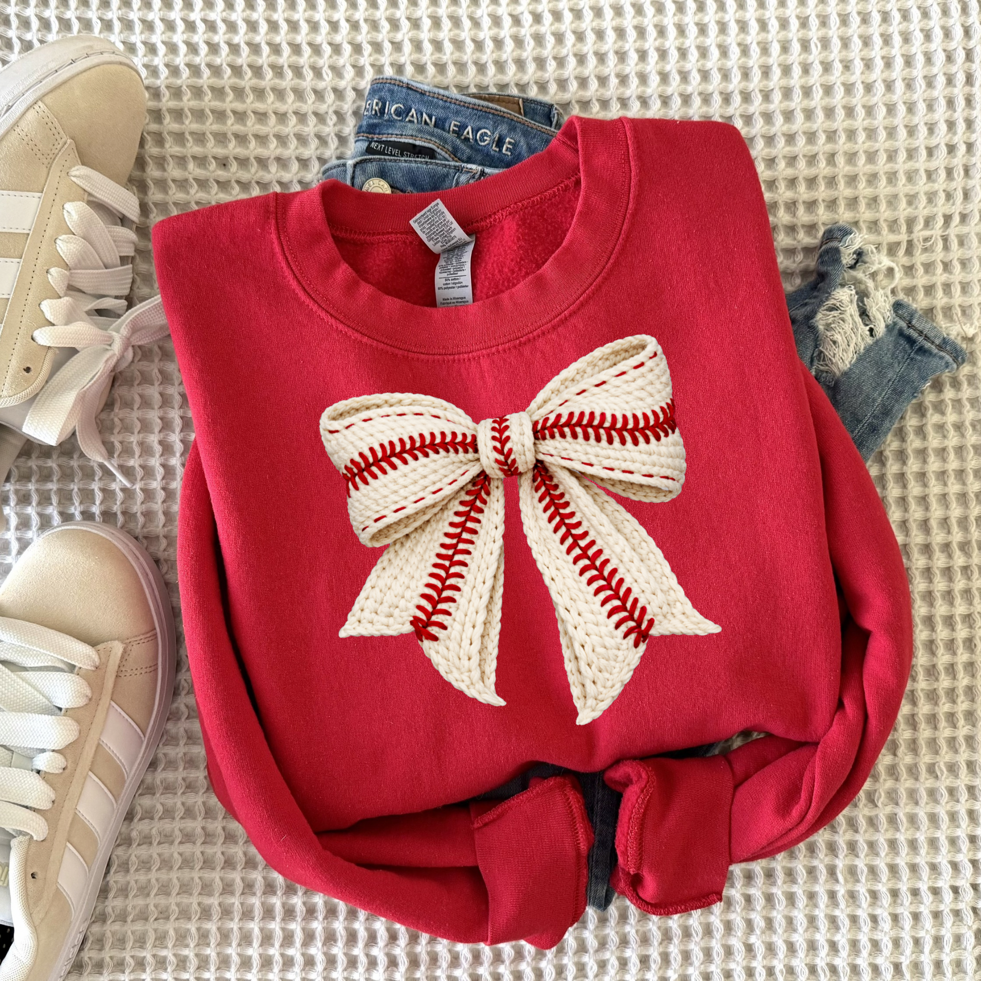 Cozy women’s crewneck sweatshirt featuring a faux yarn style baseball bow graphic, perfect for baseball moms, game day outfits, and casual sporty everyday wear.