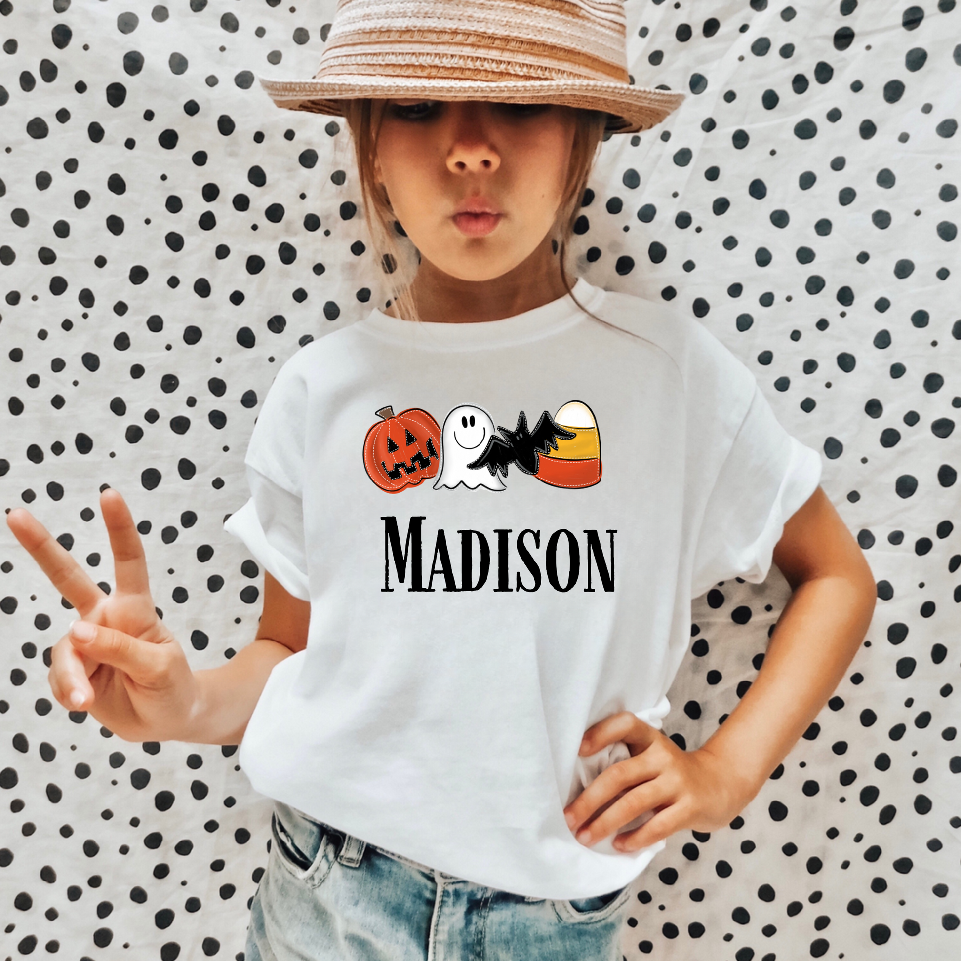 A personalized Halloween shirt for kids with a cute ghost design and their name, adding a unique and preppy touch to their Halloween outfit. The shirt embodies the spirit of Halloween with a playful 'boo' charm and pumpkin accents.